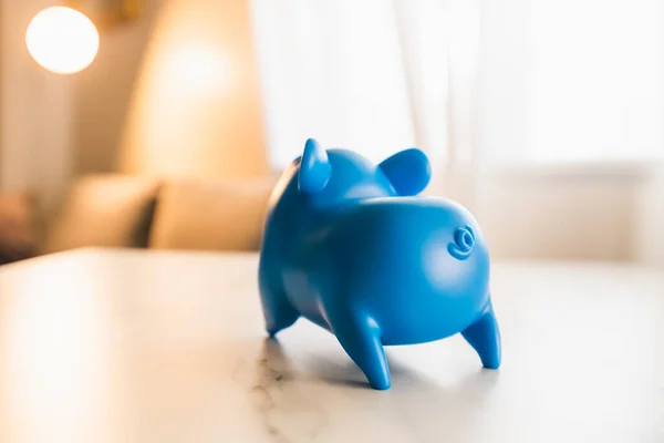 Blue piggy bank box put on the table with soft light and copy space. Saving money concept.