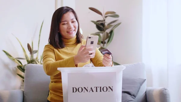 亚洲妇女使用信用卡按下电话在线支付预订捐款箱送货 — 图库照片