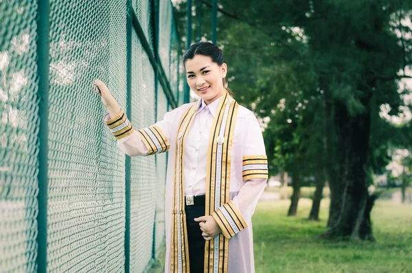 O retrato de formatura feminina em vestido acadêmico está procurando forwa — Fotografia de Stock