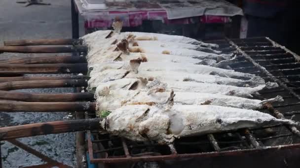 新鲜美味的烤鱼、 罗非鱼、 尼罗河鱼用盐。用木炭户外在泰国街头市场上出售的黑暗烧伤皮肤 — 图库视频影像