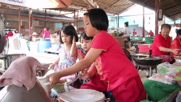 Ayutthaya, Thaiföld - február 22-én, 2015:Three lányok segítik a vonat a helyi pék eladni a turisták számára, akik a piac Thaiföld utazás — Stock videók