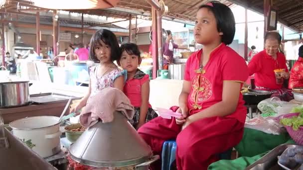 Ayutthaya, Tailandia - Feb 22, 2015: Tres niñas están ayudando a entrenar a panaderos locales para vender a los turistas que viajan en el mercado en Tailandia — Vídeos de Stock