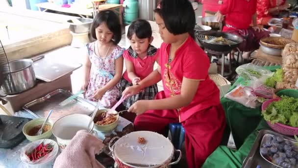 Ayutthaya, Thailand - Feb 22, 2015:Three girls are helping to train local baker to sell to tourists who travel in the market in Thailand — Stock Video