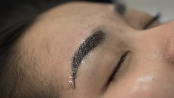 Maquillaje ceja tatuaje, bastante asiático mujer cara primer plano — Vídeos de Stock