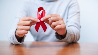 Kırmızı kurdele ile HIV / AIDS farkındalığının önemini vurgulayan güçlü bir görüntü.