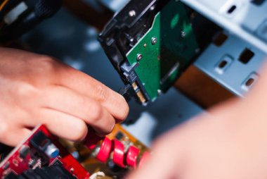 Bir teknisyen bir teknoloji atölyesinde bilgisayar donanımını ustalıkla tamir eder..