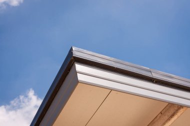 Parlak bir bina, açık mavi gökyüzüne karşı modern tasarımı yansıtır..