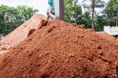 Yeşilliklerle çevrili bir şantiyedeki toprak yığınının yakın görüntüsü..