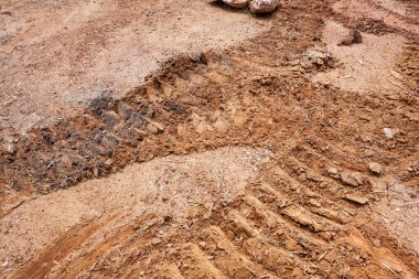 Heavy machinery leaves distinct tracks in soil showcasing transformation of an outdoor construction site.