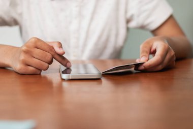 Modern bir yaşam tarzında dijital finansman sunan ve evinde cep telefonu ödemesi yapan birine yakından bakın..