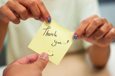 Yakın çekim, meslektaşlar arasındaki samimi bir teşekkür notu alışverişini yakalıyor..