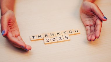 2025 'i dört gözle bekleyen içten bir şükran ifadesi. Oyuncu mektuplar ve ellerle sembolize ediliyor..