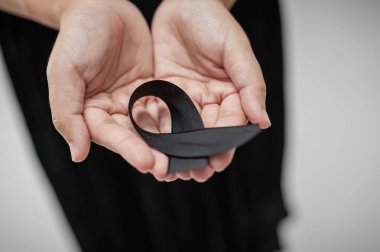 Siyah kurdelelerin dokunaklı gösterisi, yürekten bir cenaze töreninde yasını simgeler..