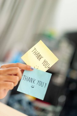 Parlak bir ofis alanında minnettarlığını ifade eden renkli yapışkan notların yakın çekimi..