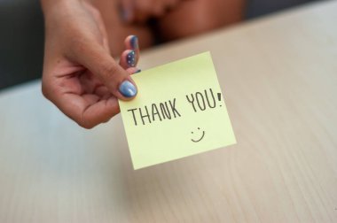 El yazısıyla yazılmış bir teşekkür notu. Bir teşekkür jesti sergileyen bir masa..