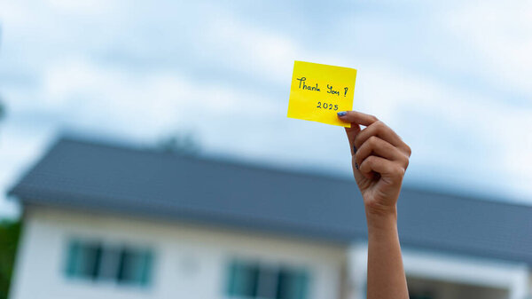 Человек выражает благодарность, держа записку на открытом воздухе, демонстрируя общественный дух и признательность.