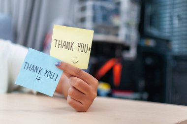 Samimi bir ofis ortamındaki renkli teşekkür notlarıyla elde edilen kişisel bir minnettarlık dokunuşu..