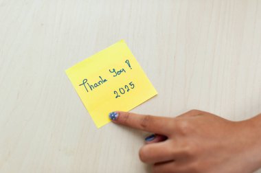 Bir el, işyerindeki memnuniyeti simgeleyen yapışkan bir nota işaret eder..