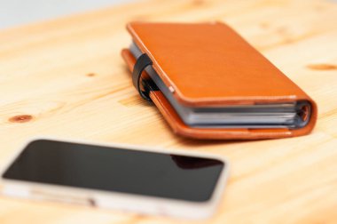 Günlük üretkenlik için temel gereksinimleri vurgulayan bir not defteri ve akıllı telefon içeren sakin bir çalışma alanı.