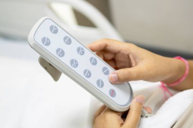 Hastanenin yatağını uzaktan kumandayla düzelten bir hasta iyileşme sürecinde rahatlık sağlar..