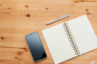 Bir not defteri ve ahşap bir masa barındıran minimalist bir çalışma alanı. İlham için mükemmel..