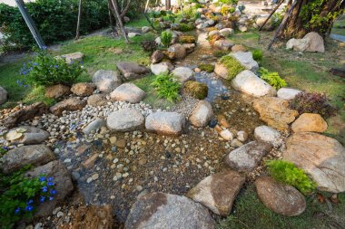 Huzurlu bir dere, yemyeşil bir bahçede esiyor. Doğanın güzelliğini ve huzurunu gözler önüne seriyor..