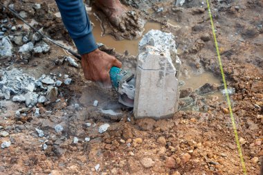 Bir işçi inşaat alanındaki betonu ustalıkla keserek endüstriyel teknikleri ve sıkı çalışmayı sergiliyor..