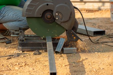 Güçlü bir metal testeresi, inşaat alanında kıvılcımlar çıkartıyor..