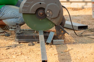 Yetenekli bir işçi, endüstriyel bir ortamda titizlikle metal vitrinleri ve işçiliğini kesiyor..