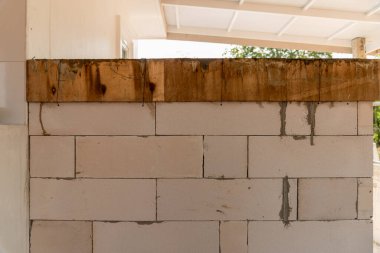 İnşaat malzemelerinin ve işçiliğin altındaki bir duvarın yakın plan görüntüsü.