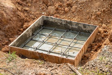 İnşaat sahasında yeni bir yapının temelini gösteren beton bir temel oluşturuldu..