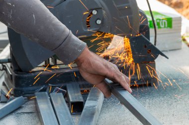 Bir zanaatkar ustalıkla metali keser şehir atölyesinde kıvılcımlar yaratır.