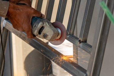 Bir zanaatkar ustalıkla metali öğütür dinamik bir atölye ortamında kıvılcımlar yaratır..