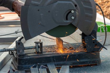 Metal kesme işlemi, inşaat etkinliği ve güvenliğini vurgulayan kıvılcımlar oluşturur.