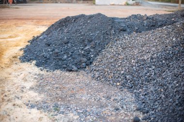 İnşaat malzemelerinin sergilendiği bir sanayi bölgesindeki çakıl ve kaya stoklarının genel görünümü.