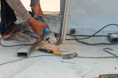 Bir zanaatkar, canlı bir atölye ortamında metali şekillendiren bir öğütücüyü ustaca yönetir..