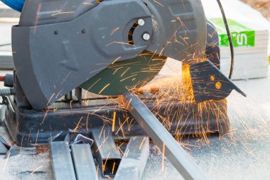 Metal kesme testeresi çelik gibi kıvılcımlar saçar. Endüstriyel atölyede ustalıkla kesilmiş..