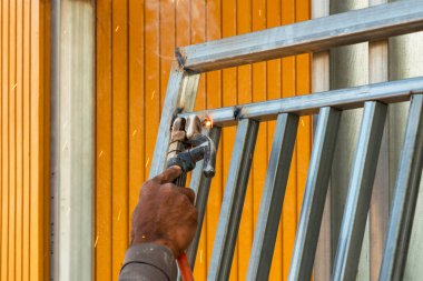 Çalışan bir inşaat alanında ustaca kaynak yapan bir usta kıvılcımlar saçar..