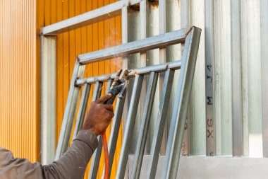 Bir endüstriyel atölyede ustalıkla metal çerçeve kaynatıyor..