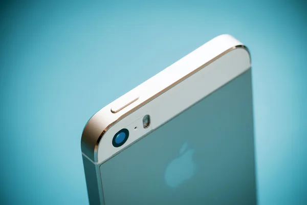 The gold Apple iPhone 5s on blue paper background — Stock Photo, Image