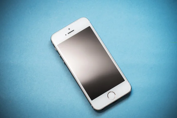 L'or Apple iPhone 5s sur fond de papier bleu Photo De Stock