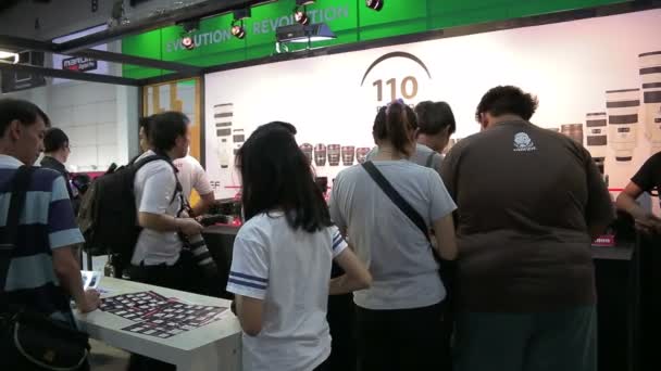 Menschen jeden Alters besuchen und kaufen die Kamera oder das Zubehör für die Fotografie auf der Fotomesse 2015 vom 25. bis 29. November 2015 auf der bitec in Bangkok, Thailand — Stockvideo