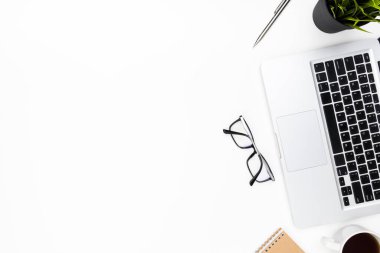 Laptop bilgisayarı, kahve ve malzemelerle dolu beyaz ofis masası. Kopyalama alanı olan üst görünüm, düz yatay.