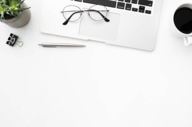 Laptop bilgisayarı, kahve ve malzemelerle dolu beyaz ofis masası. Kopyalama alanı olan üst görünüm, düz yatay.