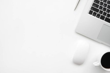 Laptop bilgisayarı, kahve fincanı ve malzemeleri olan modern beyaz ofis masası. Kopyalama alanı olan üst görünüm, düz yatay.