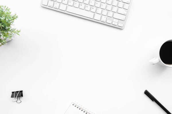 White office desk table with computer tools, cup of coffee and supplies. Top view with copy space, flat lay.