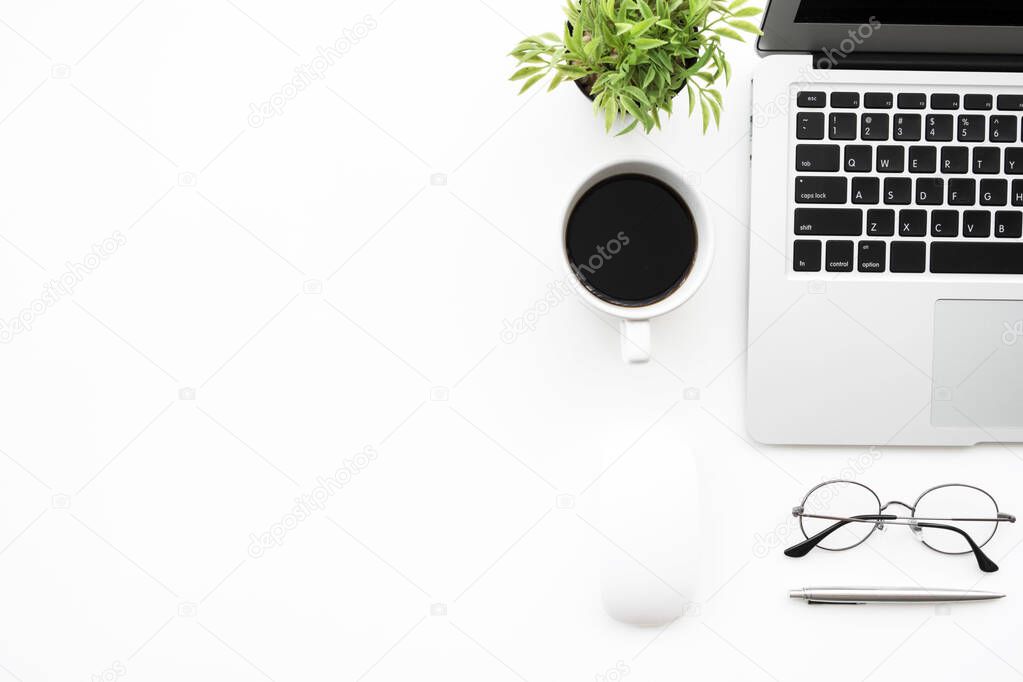 White office desk table with laptop computer, cup of coffee and supplies. Top view with copy space, flat lay.