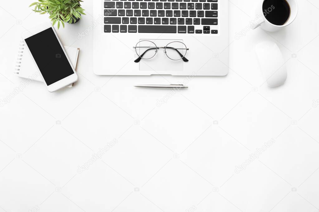 White office desk table with laptop, smartphone and supplies. Top view with copy space, flat lay.