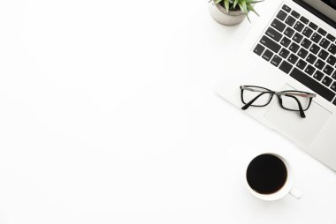 Laptop bilgisayarı, kahve ve malzemelerle dolu beyaz ofis masası. Kopyalama alanı olan üst görünüm, düz yatay.