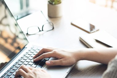 Genç adam internette bir şey aramak ve sörf yapmak için dizüstü bilgisayarda klavye kullanıyor..